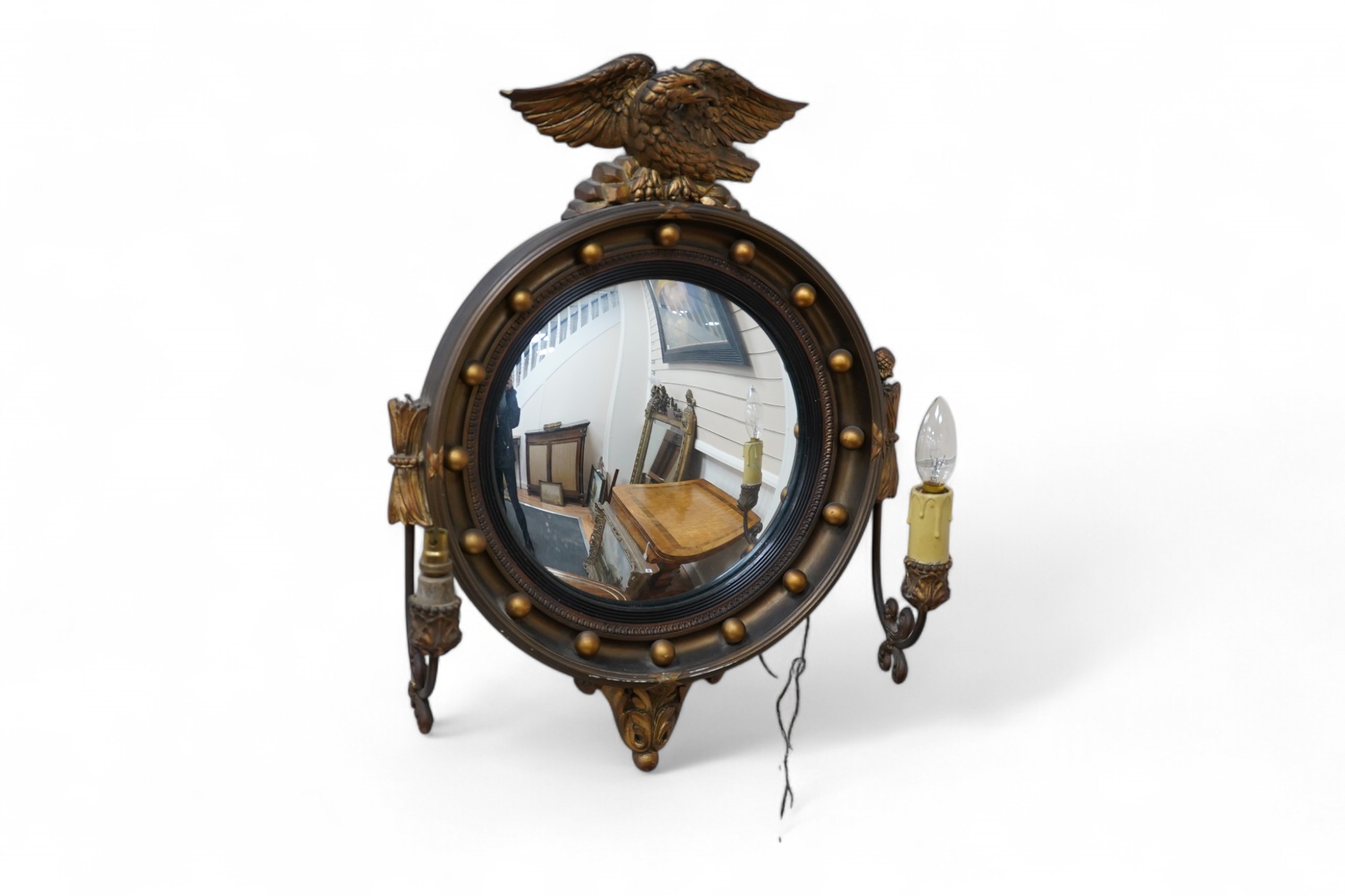 A circular convex gilt girandole mirror with carved eagle surmount, 62cm high. Condition - wing tip of eagle broken, gilt of frame scratched near the bottom, faux candle cover broken and the other missing